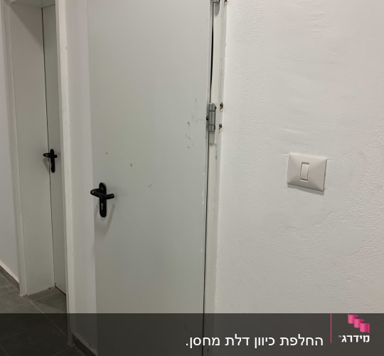 דלתות לבנות עם ידיות שחורות וצירים מתכתיים